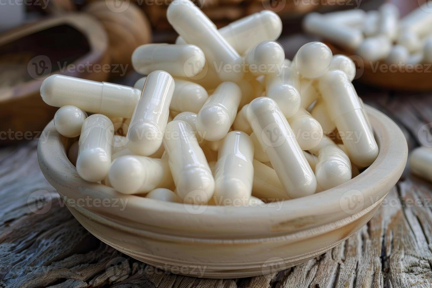 White supplement capsules piled in wooden bowl promoting health and wellness photo