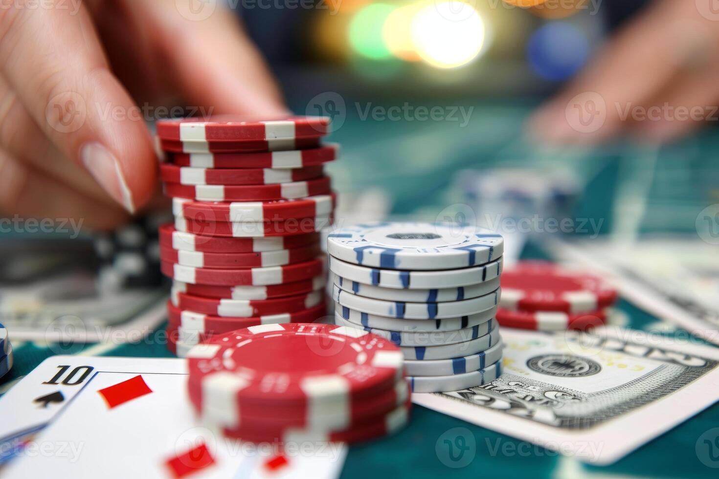 Croupier stacking poker chips on casino gambling table with us dollar bills and cards photo