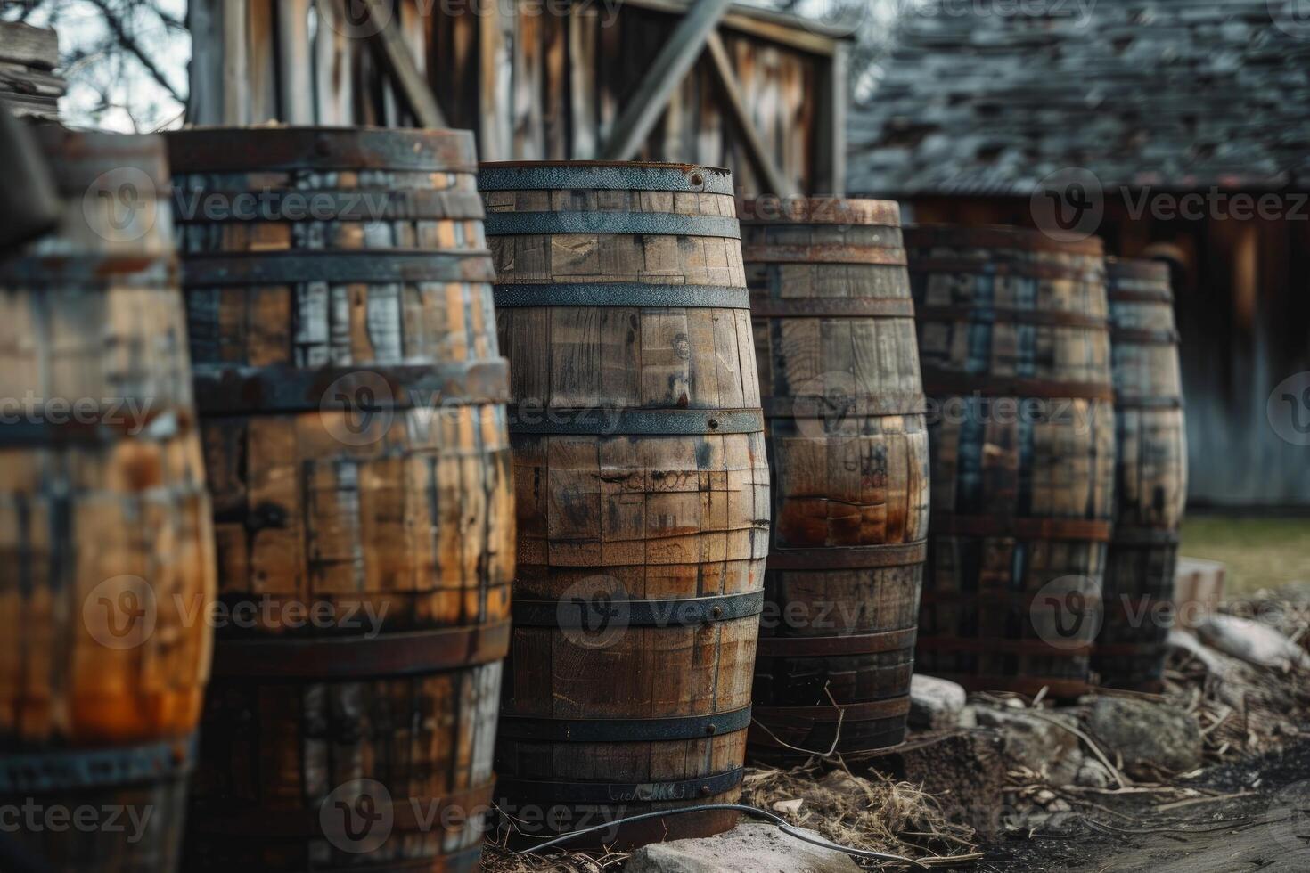 Wine barrels aging in a rustic outdoor setting near wooden building photo