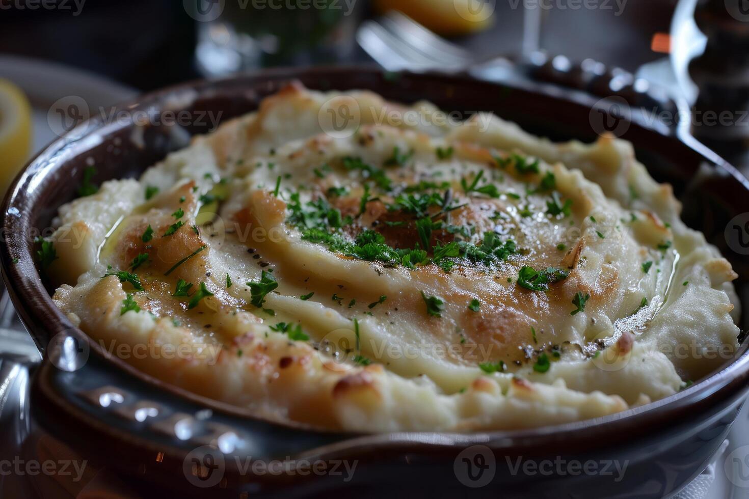 Creamy mashed potatoes sprinkled with fresh parsley and herbs in rustic bowl photo