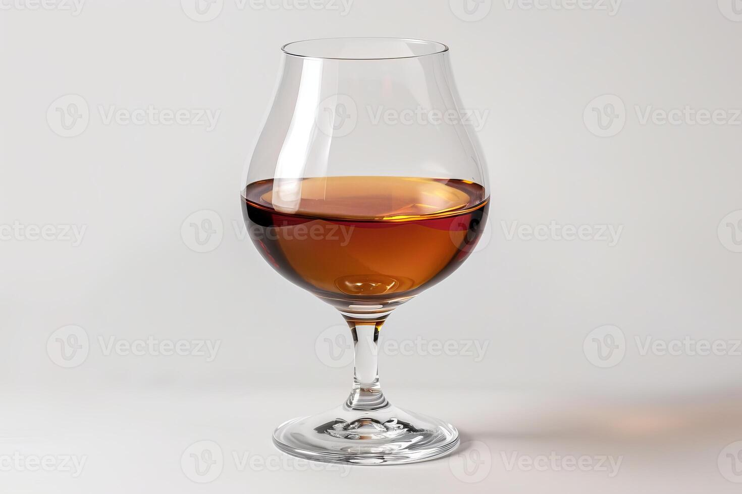 Glass of cognac or brandy standing on white background photo