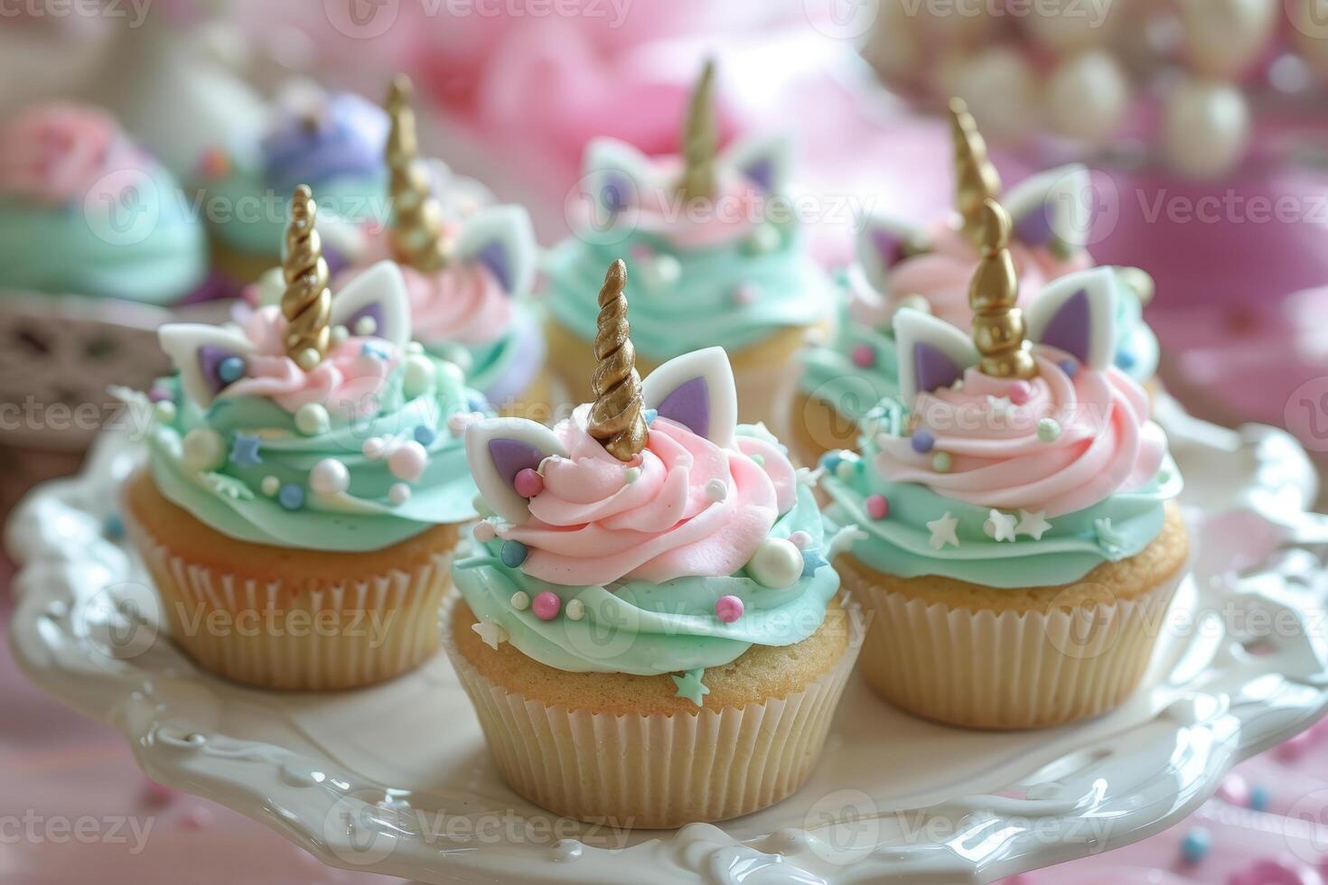 Unicorn cupcakes with pink and teal frosting on cake stand photo