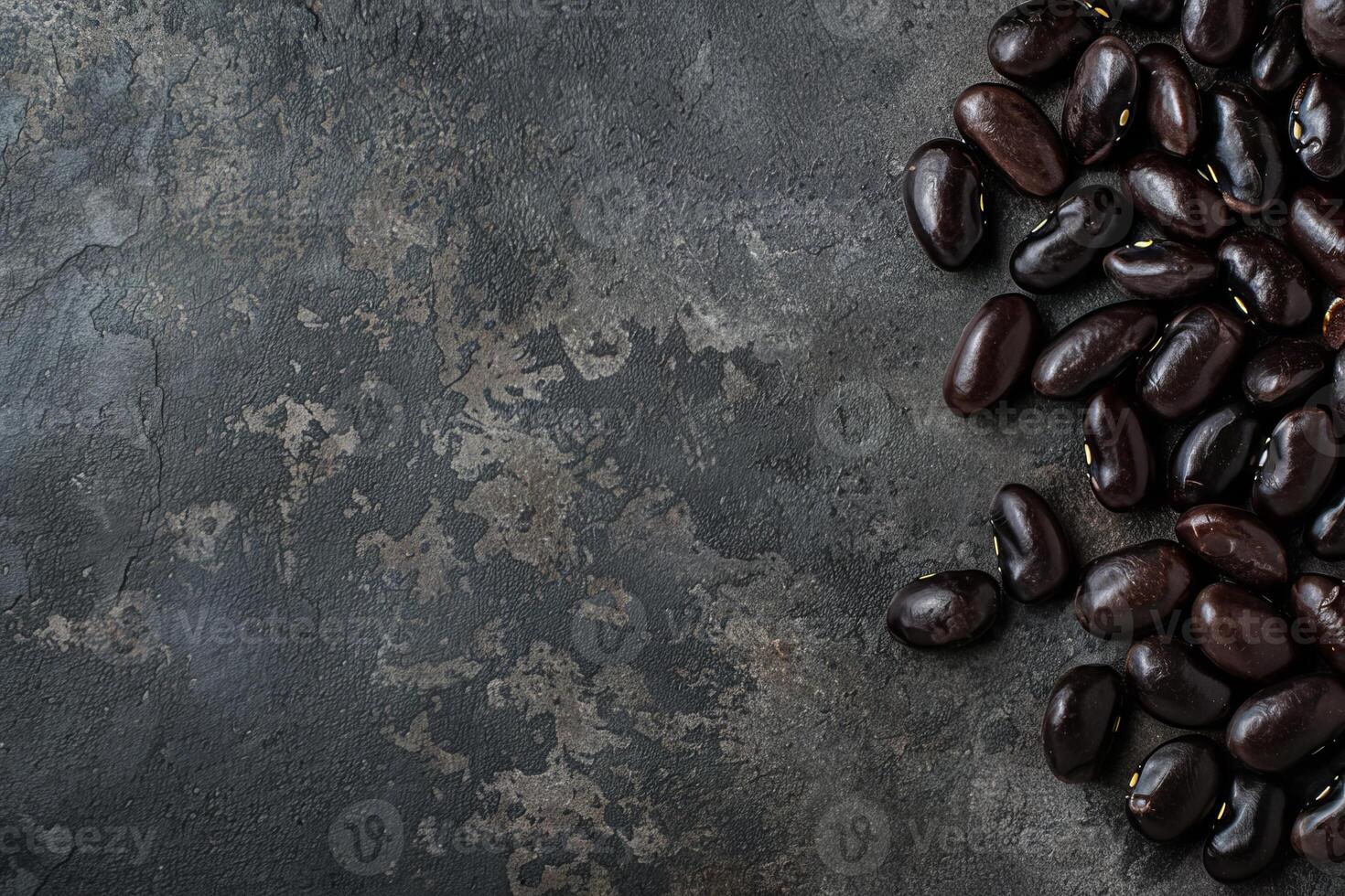 Black beans piled up on dark stone background creating negative space photo