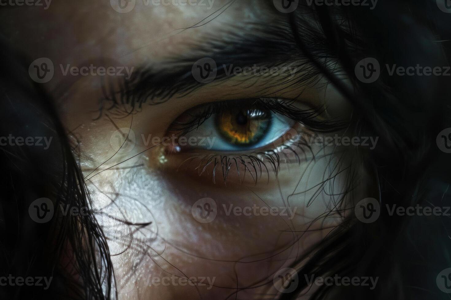 Woman showing expressive green and brown eye with long eyelashes photo