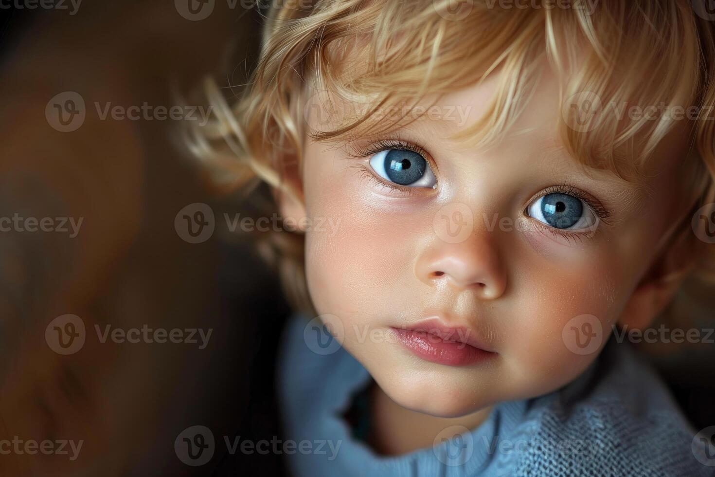Portrait of adorable toddler with blond hair and striking blue eyes photo
