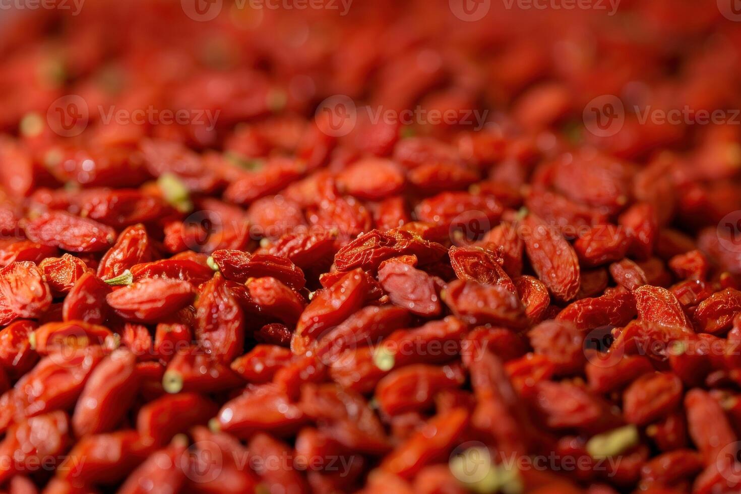 Dried goji berries filling the frame creating a vibrant red background photo