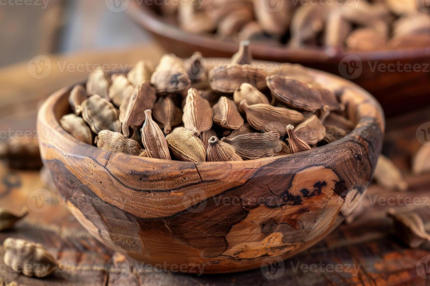 Wooden bowl overflowing with aromatic cardamom pods on rustic table photo