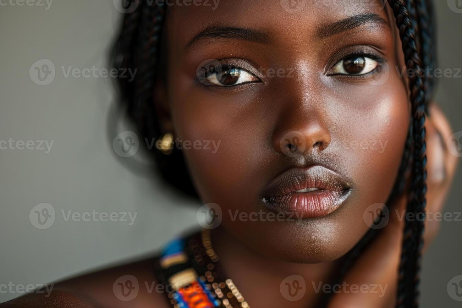 Young black woman with braids touching her hair posing for beauty portrait photo