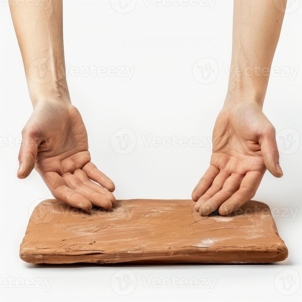 Potter presenting rectangular slab of clay on white background photo