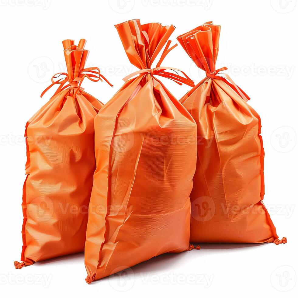 Three orange sacks tied with ribbon knots standing on white background photo