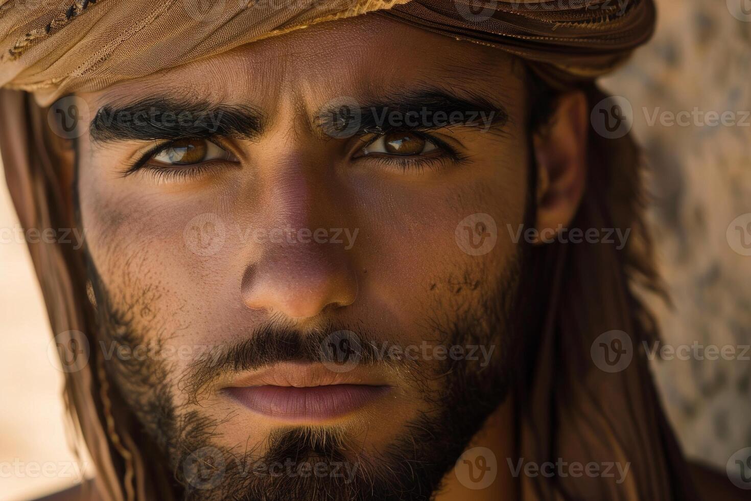 Portrait of bedouin man wearing traditional headdress in desert setting photo