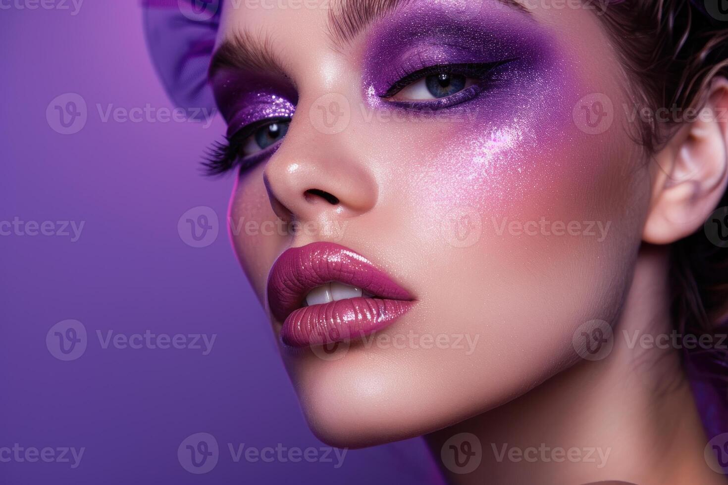 Model showing creative purple makeup with glitter and glossy lips photo