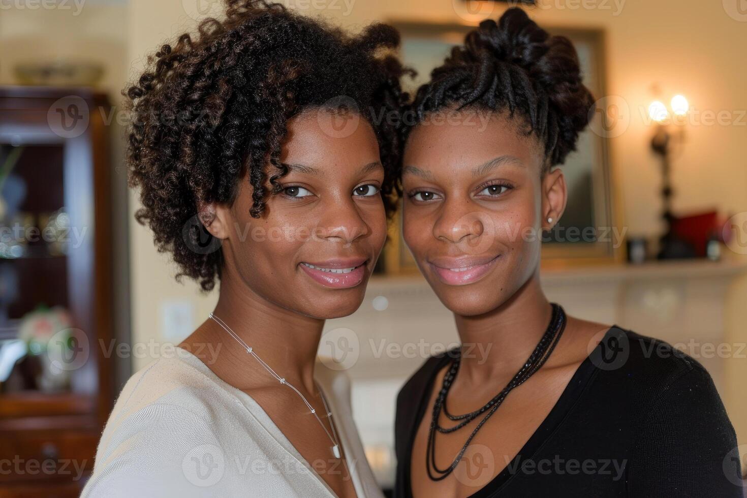 Two smiling young black women posing together indoors photo
