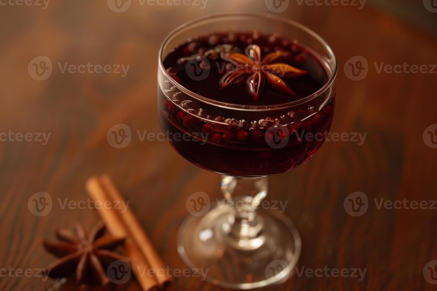 Glass of mulled wine with spices on wooden table celebrating christmas holidays photo