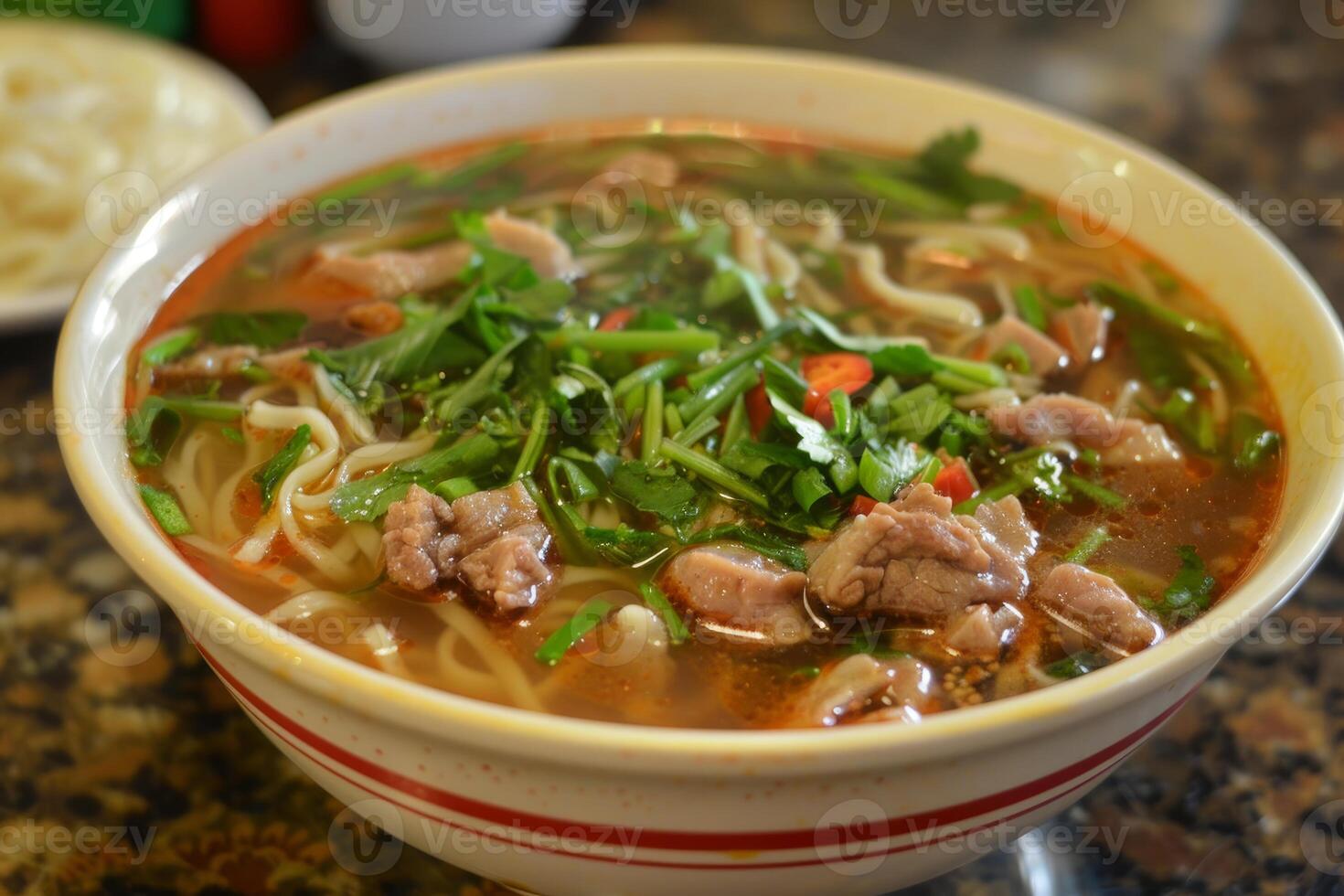 Steaming hot bowl of duck noodle soup garnished with fresh herbs photo