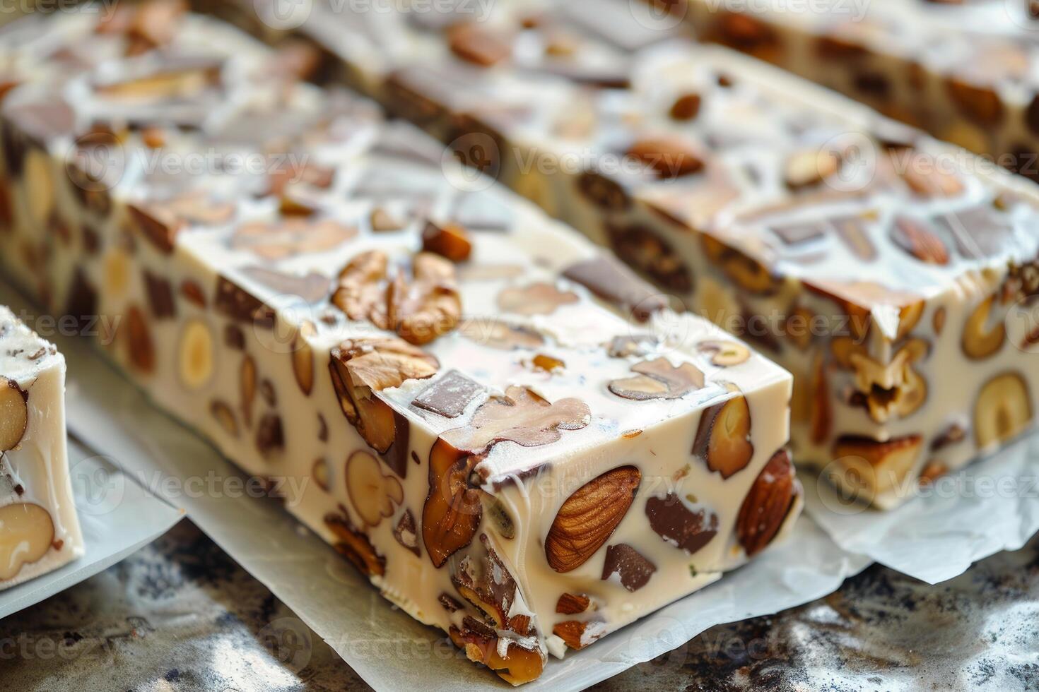 Delicious nougat bars with almonds and walnuts resting on baking paper photo