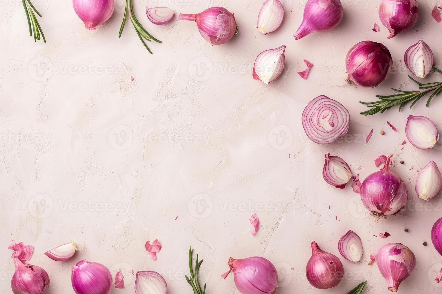 Fresh red onions and rosemary sprigs creating a frame on pink background photo