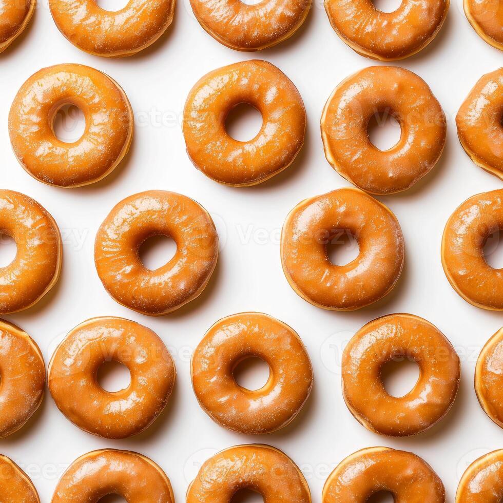 Delicious caramel donuts forming appetising pattern on white background photo