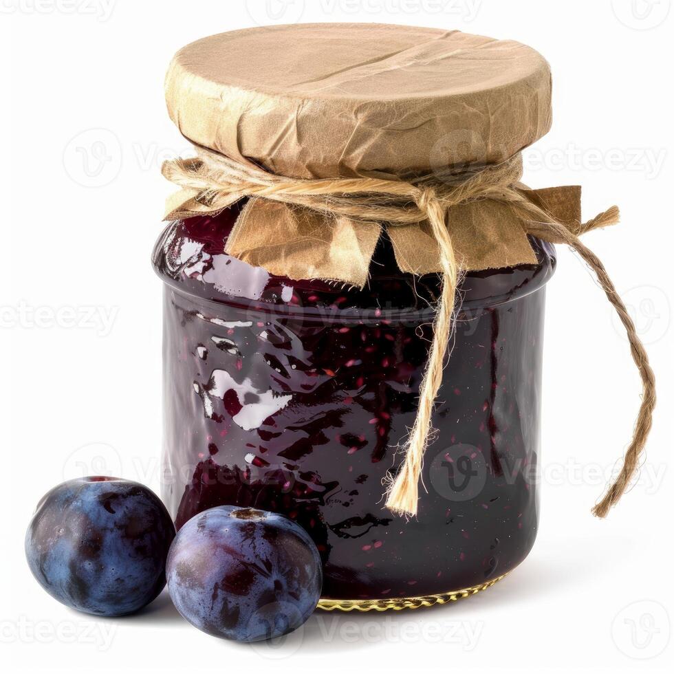 Glass jar of plum jam wrapped in brown paper and twine with fresh plums photo