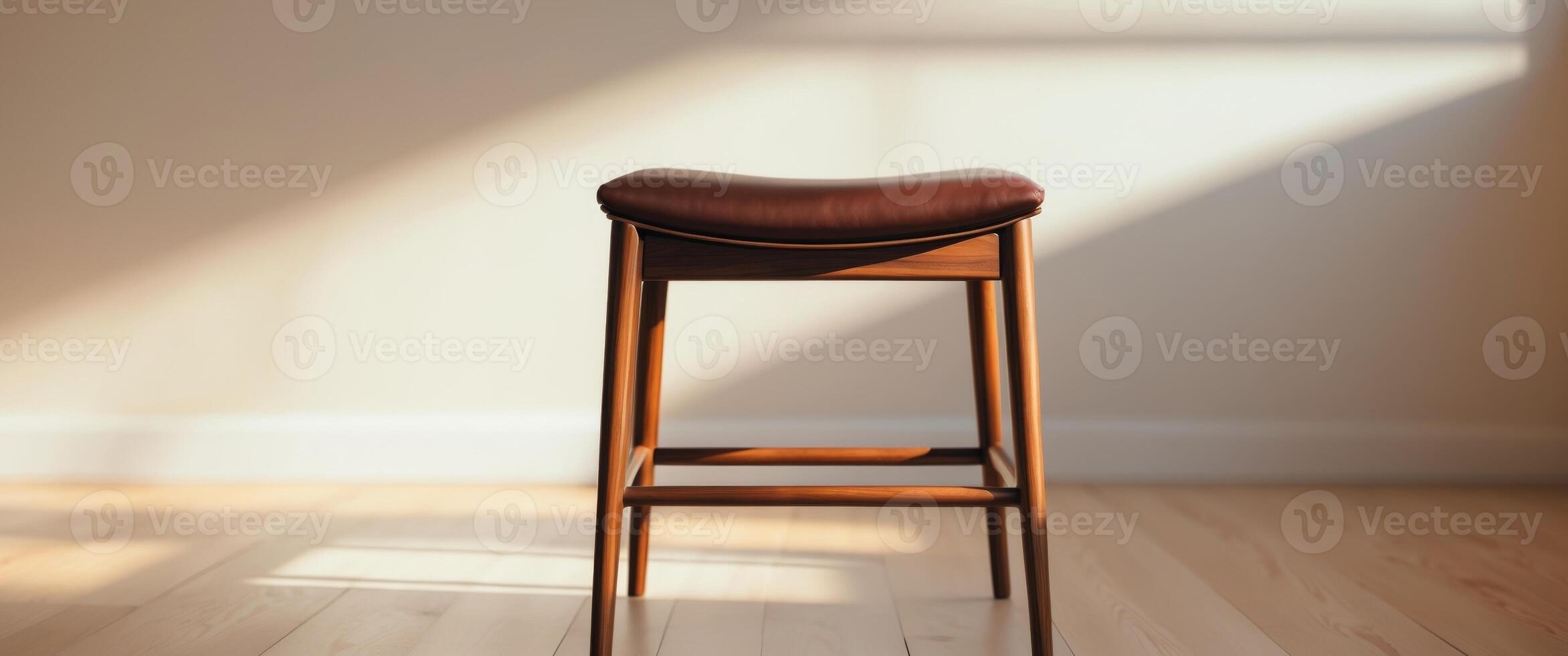 Wooden stool with leather seat in sunlight on a wooden floor indoors photo