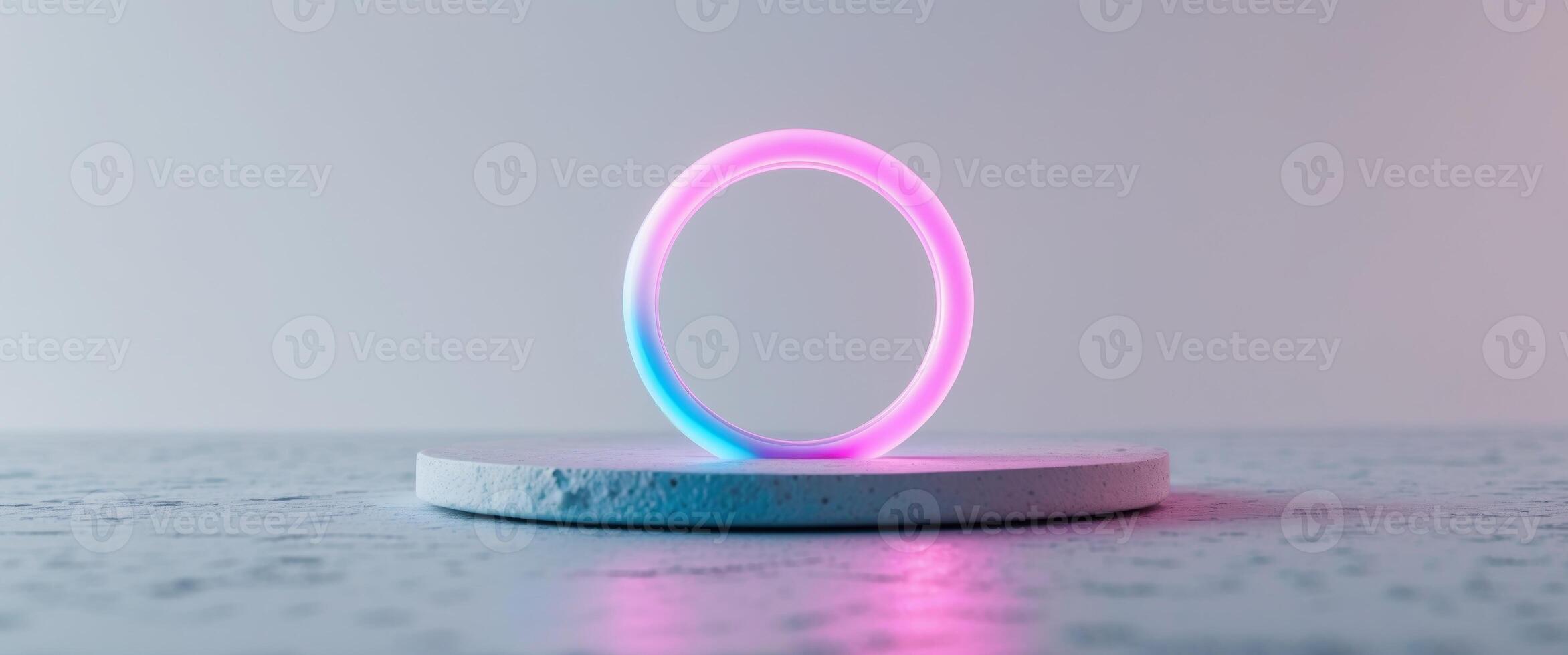 Circular neon ring with pink and blue gradient on a textured surface. photo