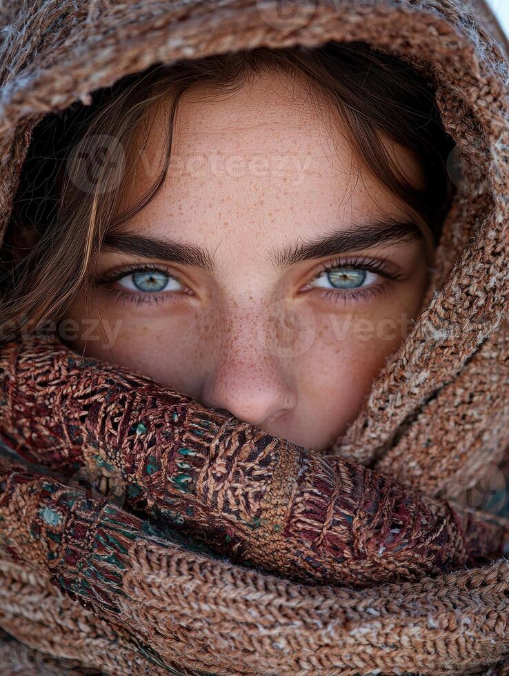 Close up portrait of a woman with freckles, wearing a warm knitted scarf photo