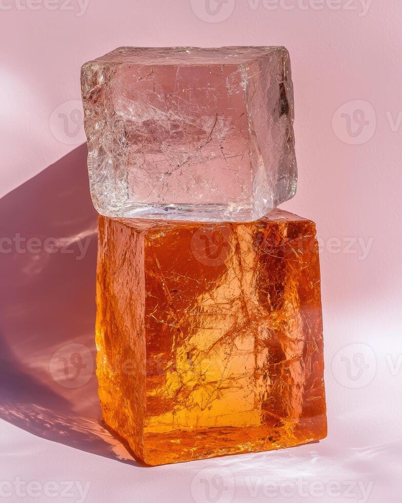 Two translucent blocks stacked on a pink background photo