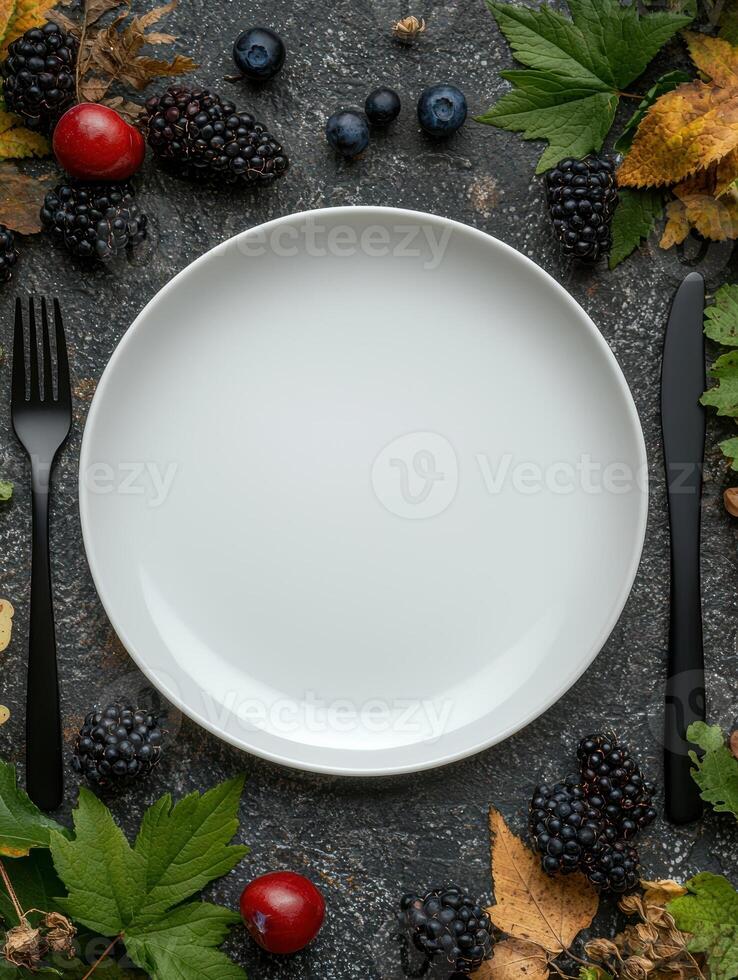Empty plate surrounded by autumn fruits and leaves photo