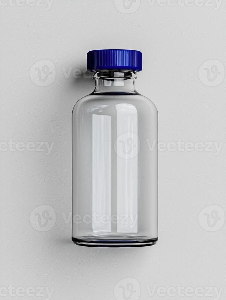 Empty glass bottle with a blue cap on a white background photo