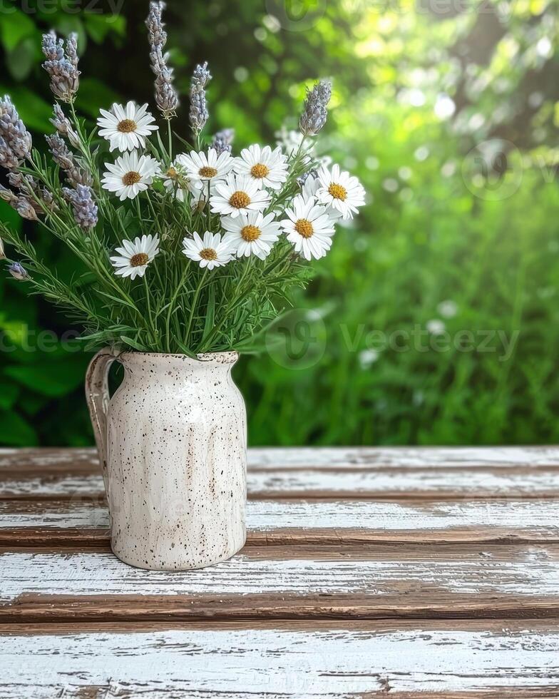 White daisies and lavender in a rustic vase on a wooden table photo
