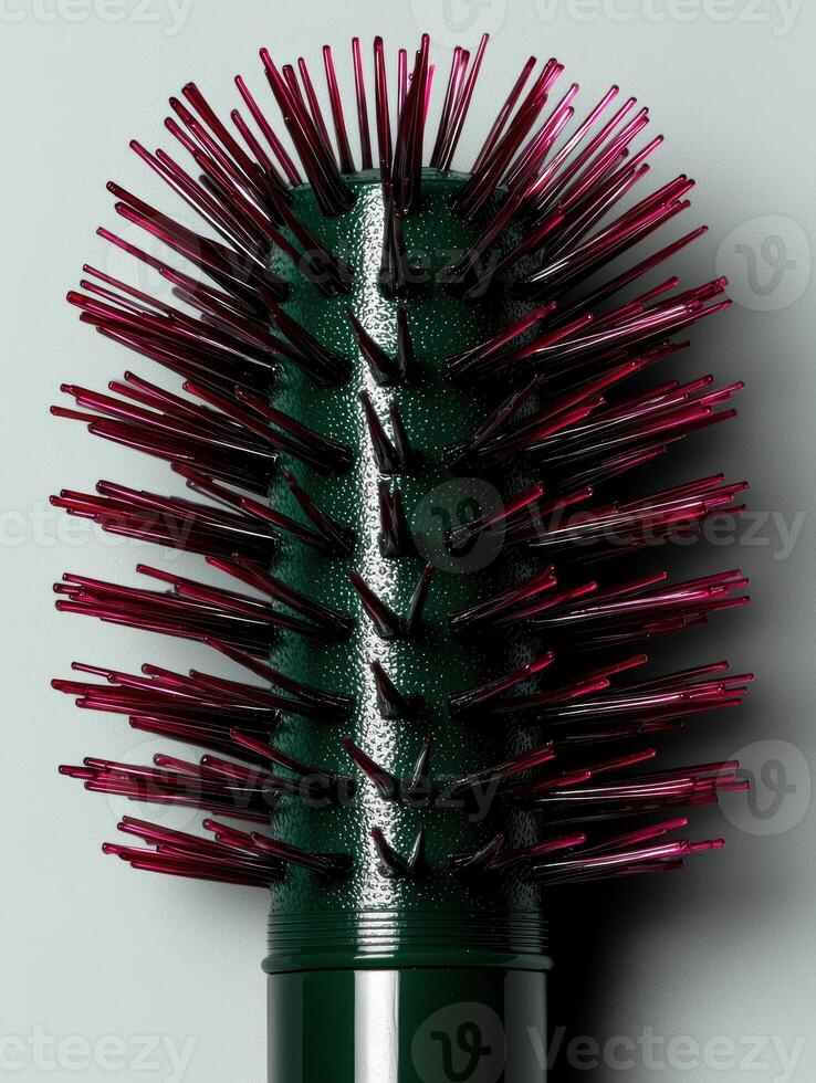 Close up of a dark green hairbrush with dark red bristles photo