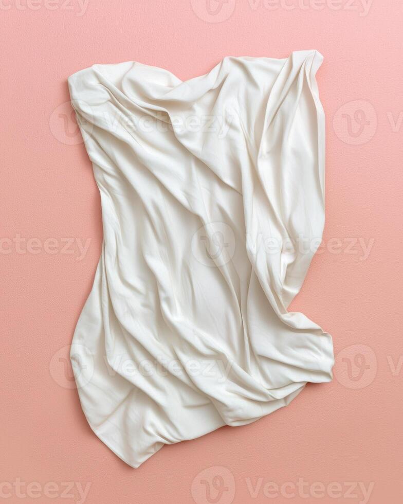Cream colored fabric draped elegantly on a pink background photo