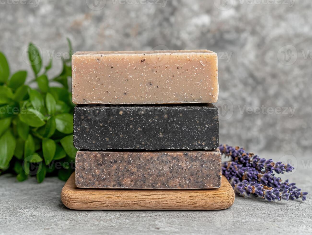 Three bars of handmade soap stacked on a wooden stand photo