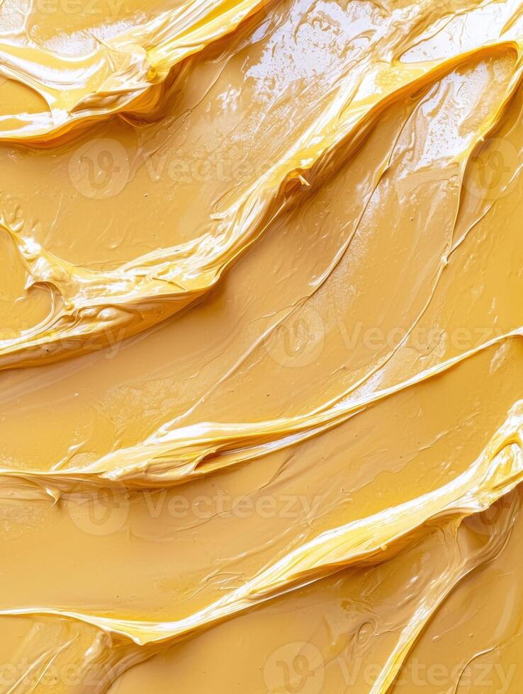 Golden swirls of creamy peanut butter texture background photo