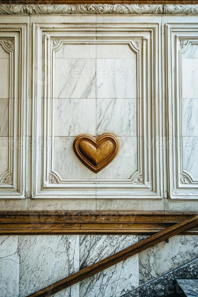 Ornate marble wall with a heart shaped carving photo