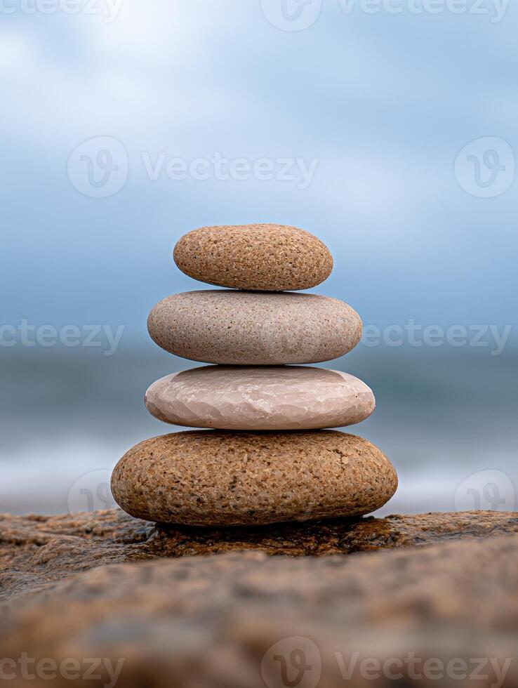 Balanced stones on a beach with a blurred ocean background photo