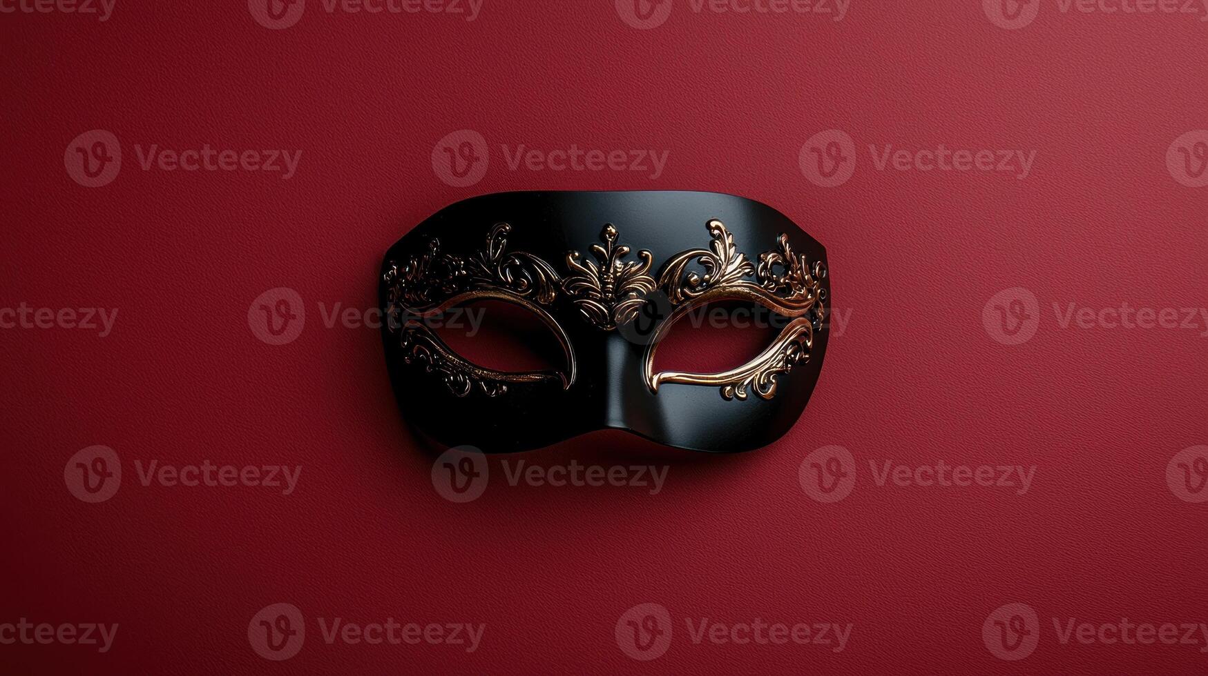 Elegant black and gold masquerade mask on red background photo