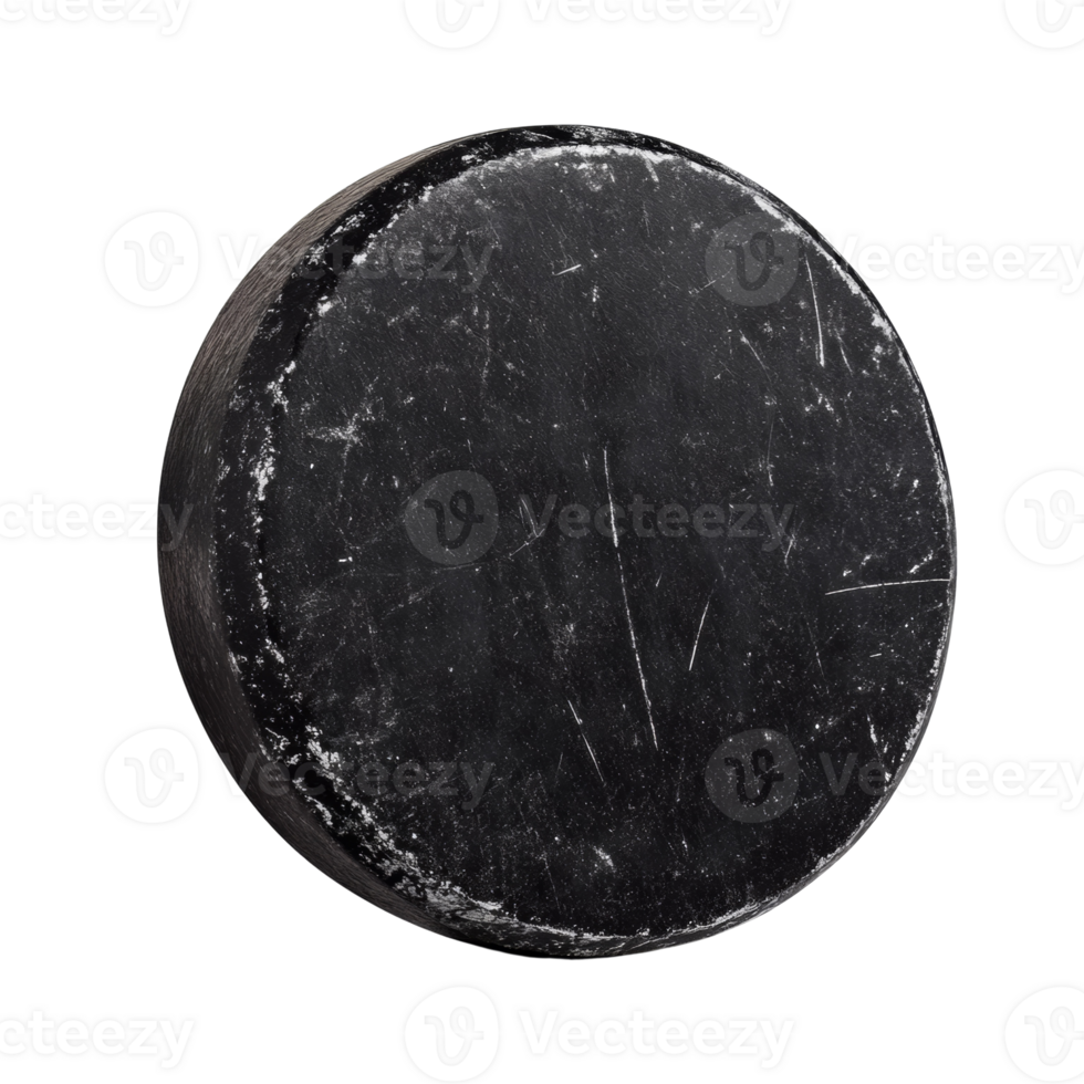 A well used black hockey puck isolated on black png