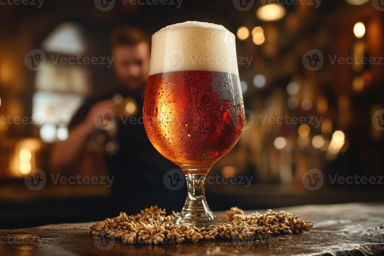 Glass of cold beer with foam and wheat on bar counter in blurred pub background photo