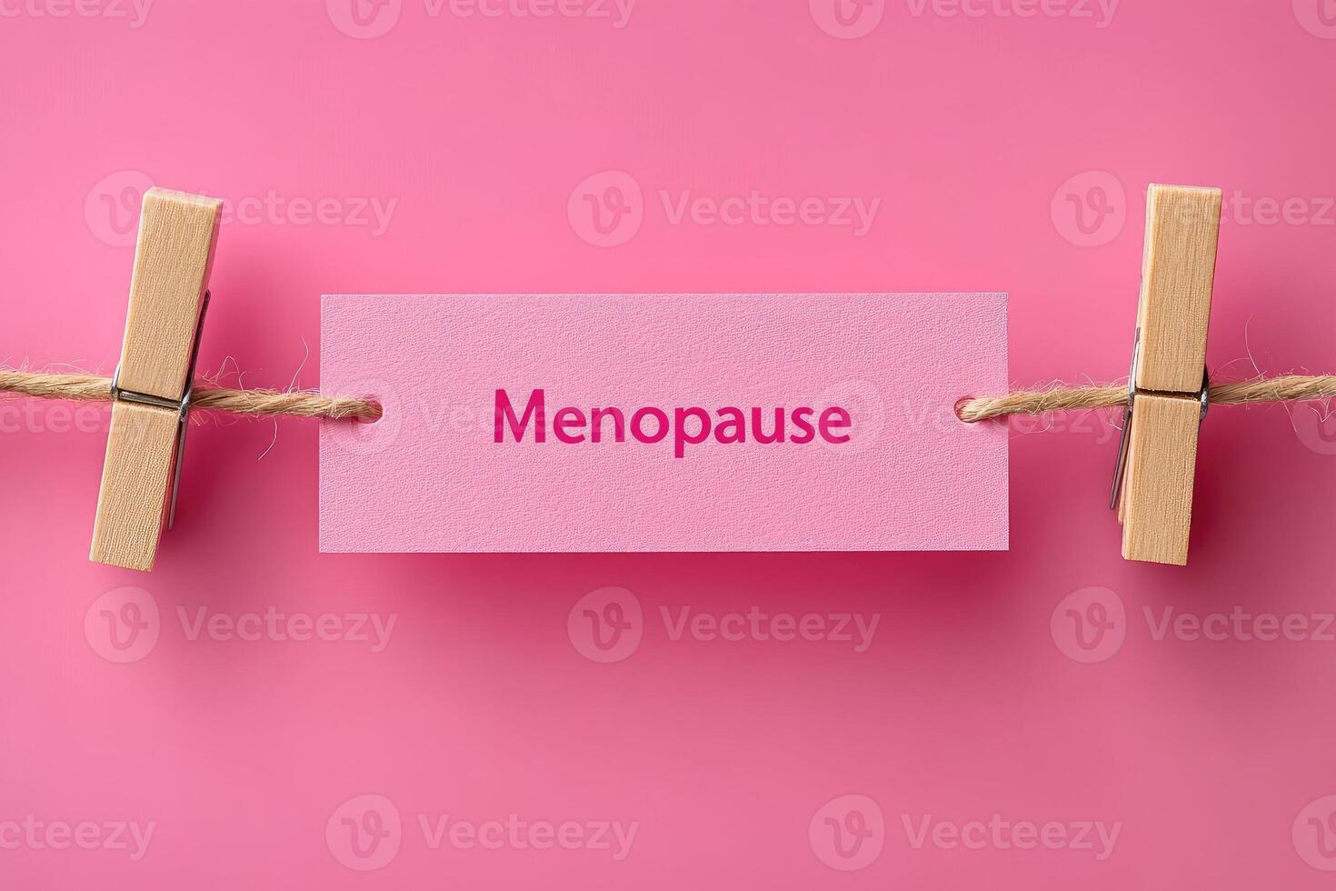 Woman holding pink menopause sign on pink background. photo