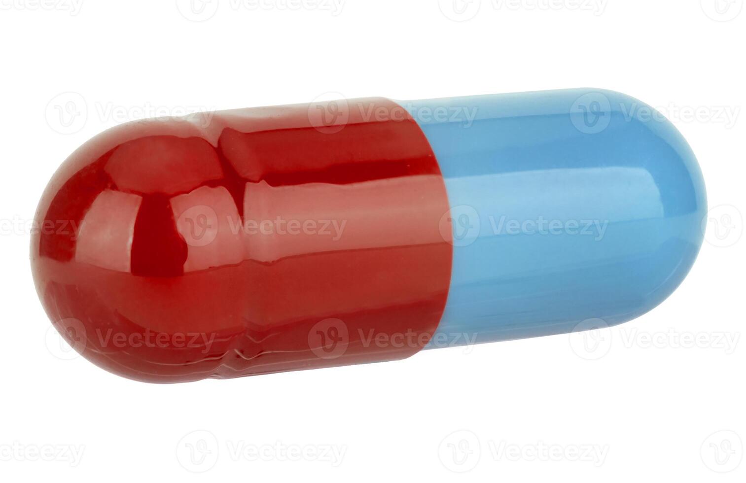 Macro photograph of large bicolored pharmaceutical capsule with shiny surface featuring bright red and light blue halves. photo