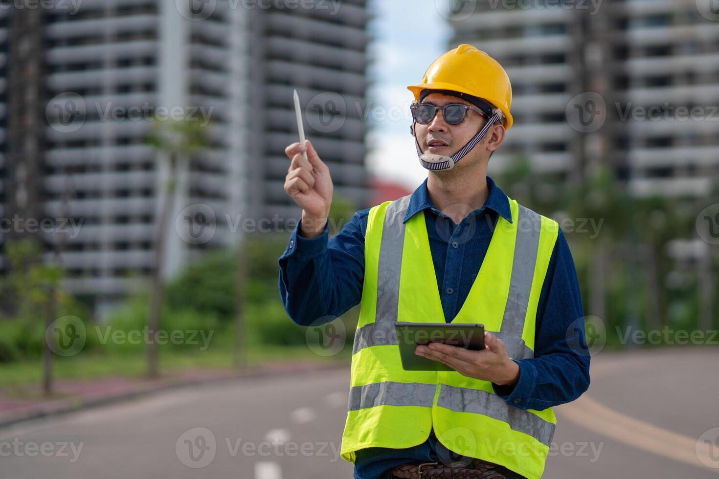 A construction site surveyor checks plans while overseeing project progress in a bustling urban environment. photo