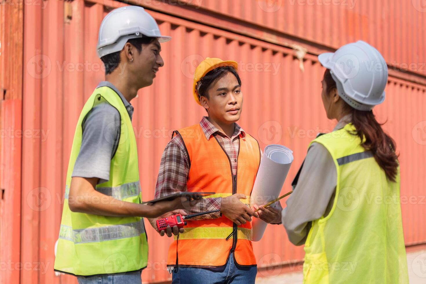 Logistics engineering team discussing project plans in a construction site with plans and tools photo