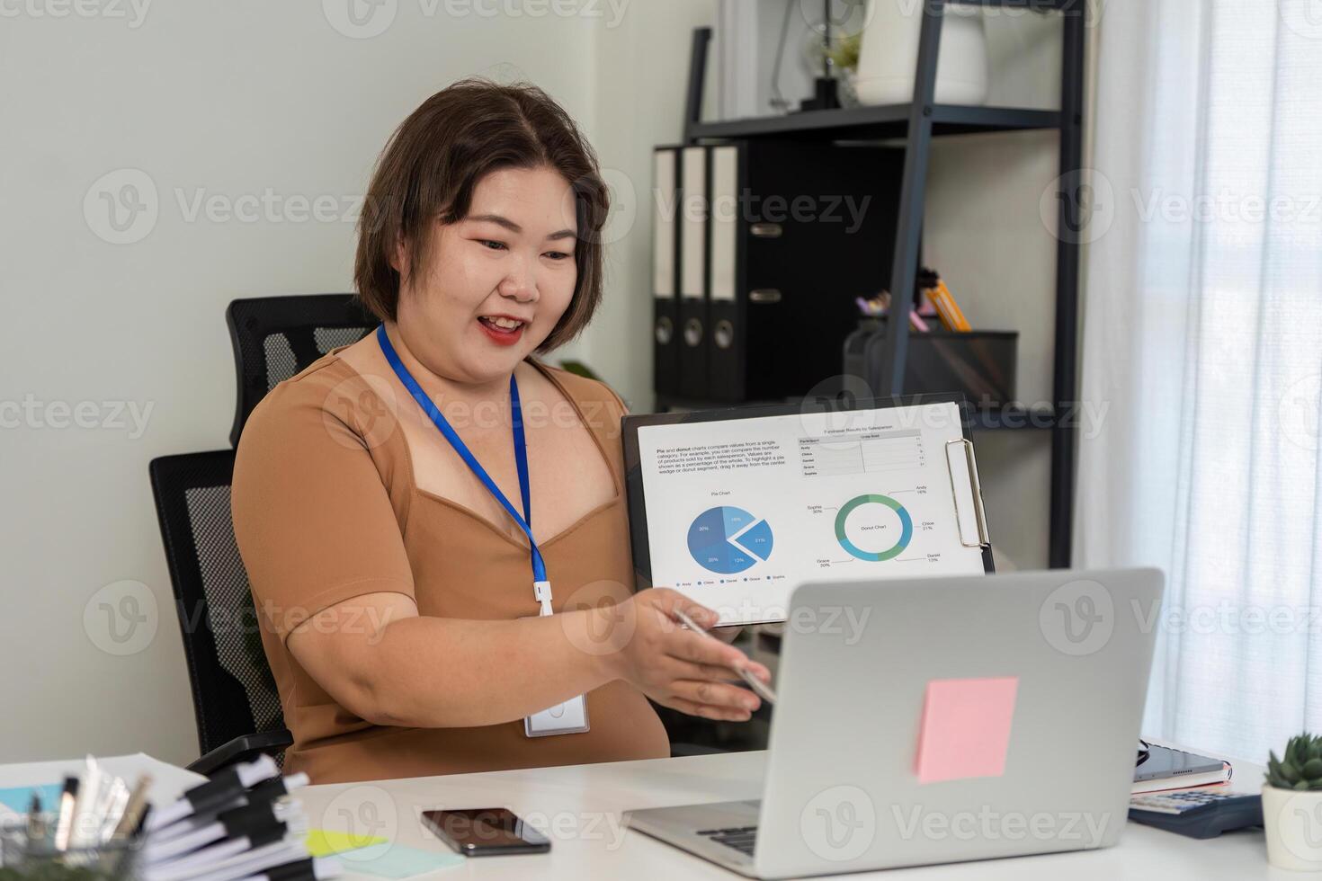 Young Businesswoman Conducts Online Meeting Presenting Financial Graphs and Data Analysis in Modern Office Setting photo