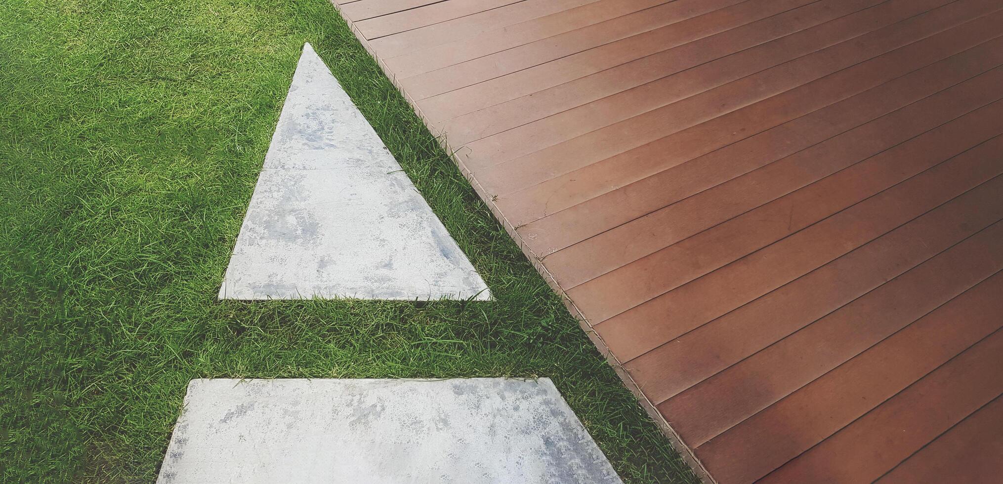 Modern art exterior design of floor with green grass, white tile and wooden. Pathway or walkway in mix with wood, concrete and lawn. photo