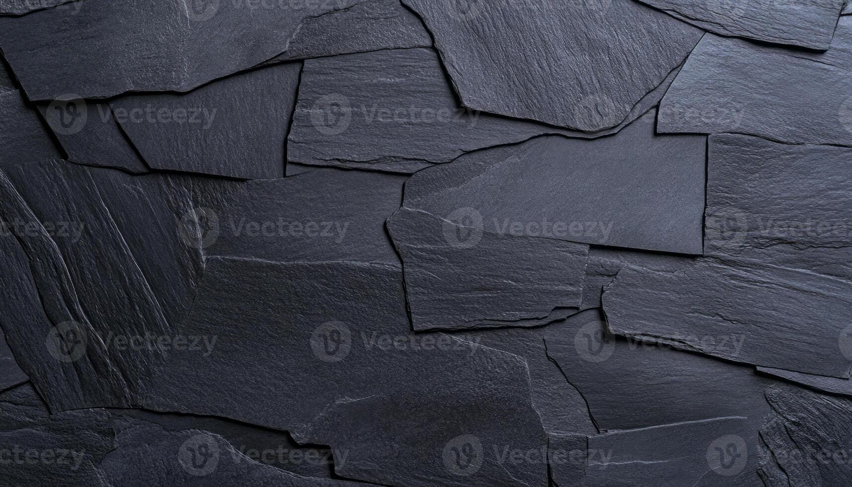 Dark slate pieces arranged in a random pattern create a unique wall texture photo