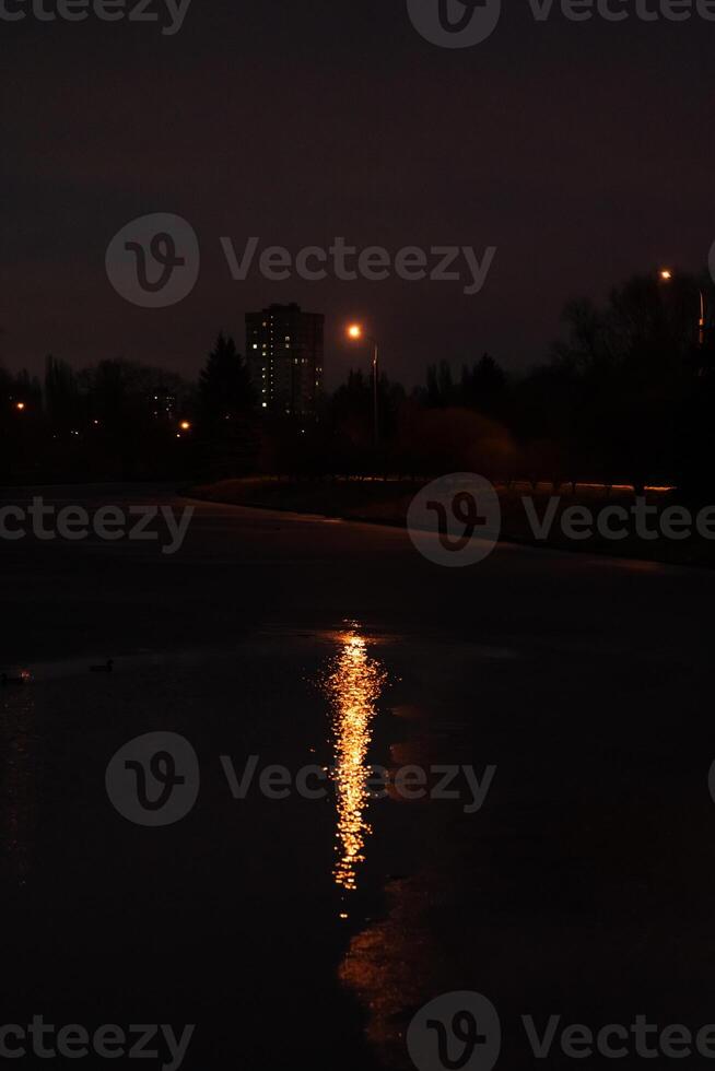 Reflection of light on the water, from a lantern at night photo