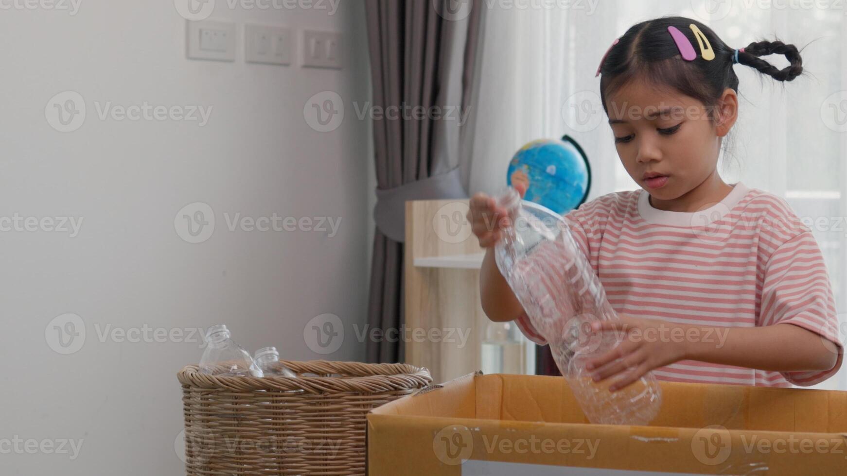 Asian little Girls dump plastic bottles in recycling boxes to reduce trash, reuse, and recycle. Recyclability and sustainability concept photo