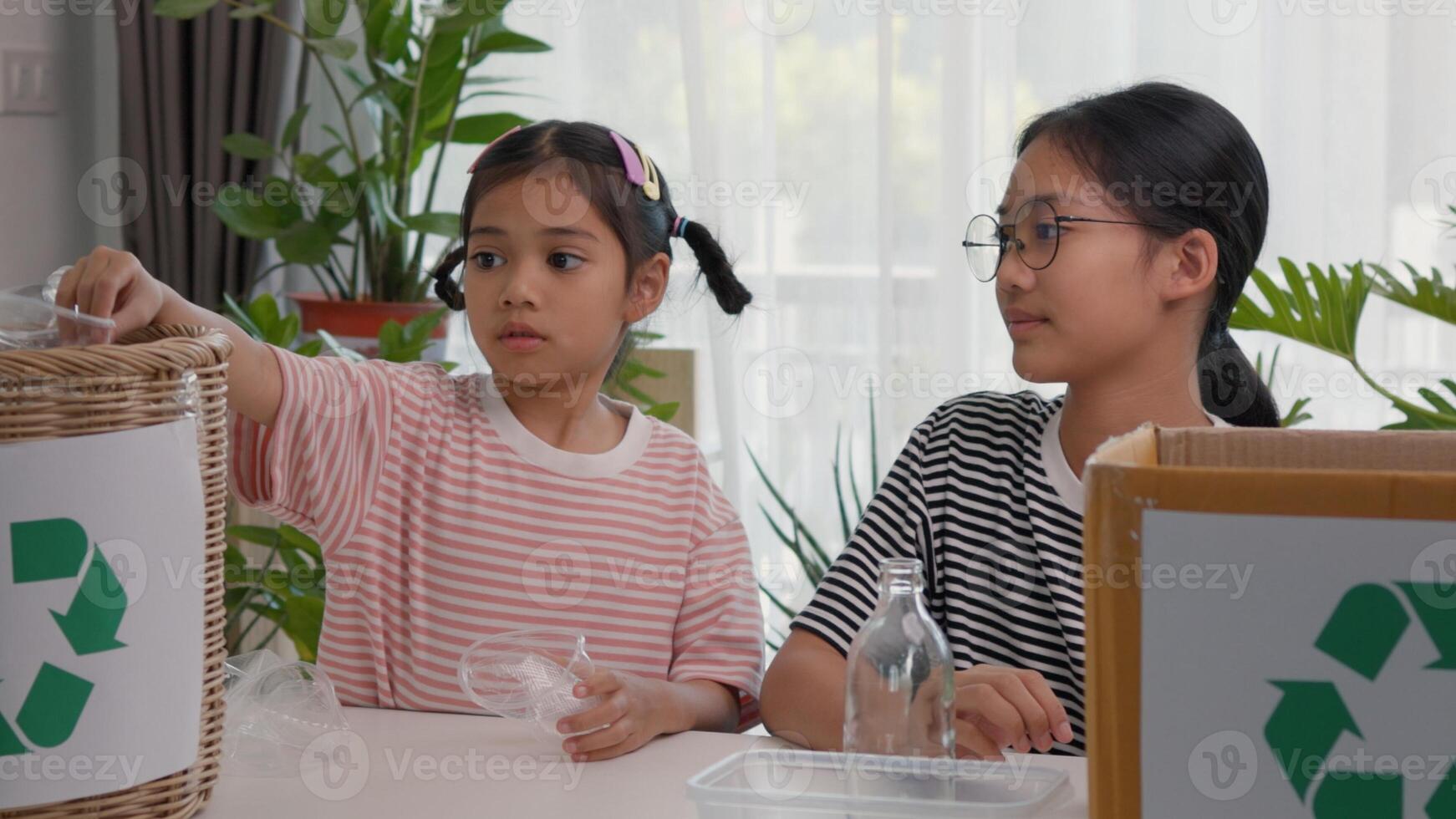 Asian siblings recycle household waste Protect nature and save the environment children learn to sort garbage by putting plastic bottles in the recycle photo