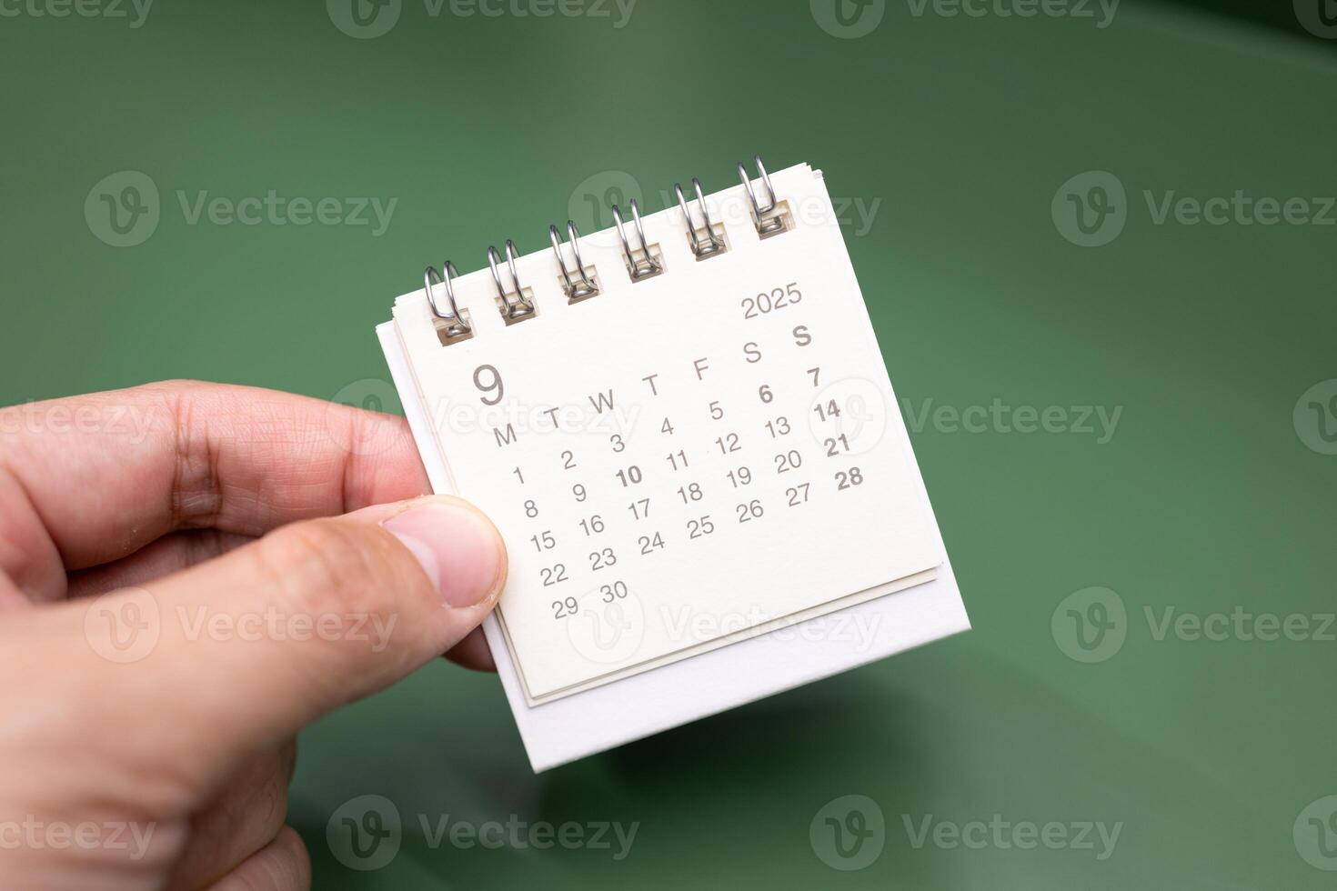 Hand holding mini calendar for SEPTEMBER 2025 background. Calendar concept with 2025 SEP calendar. photo